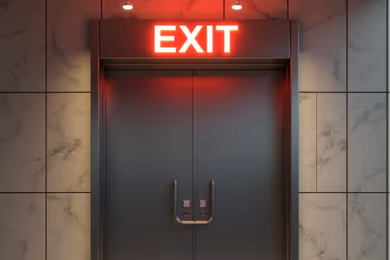 Red EXIT sign illuminating a double fire door.